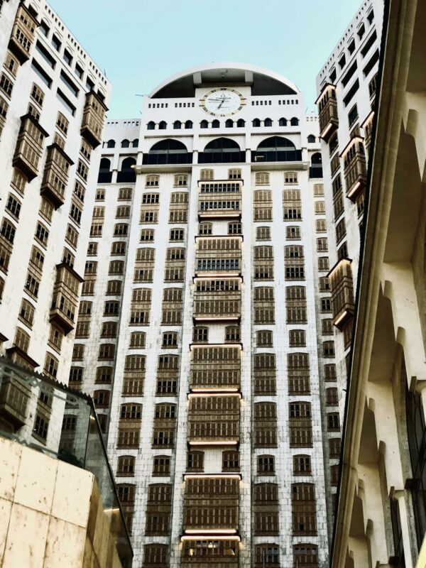 A dramatic low-angle view of a modern hotel facade in Mecca, Saudi Arabia.