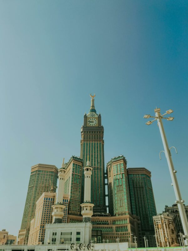 Stunning view of Abraj Al Bait Towers under a clear blue sky in Mecca, Saudi Arabia.